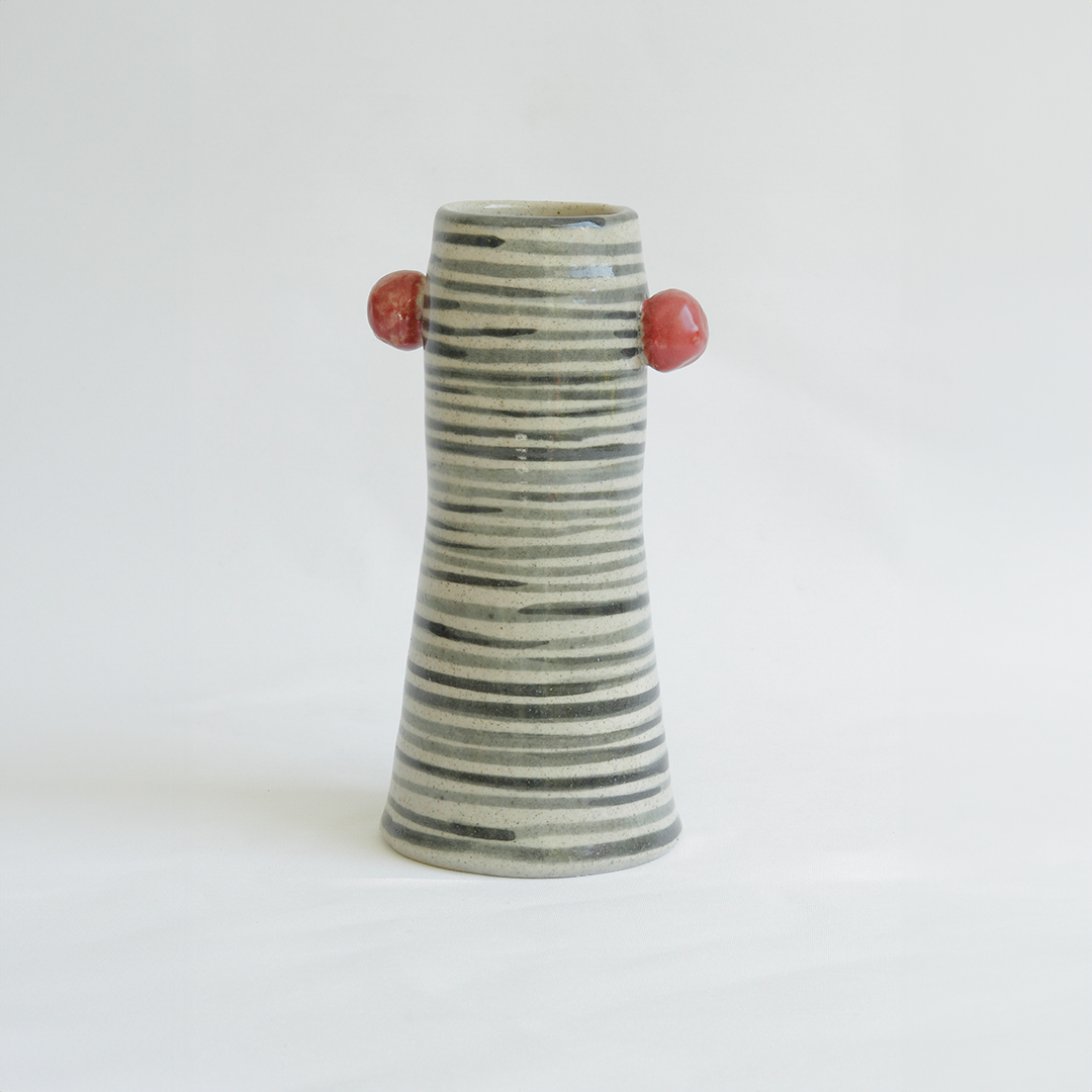 jarron de rayas negras y esferas rojas